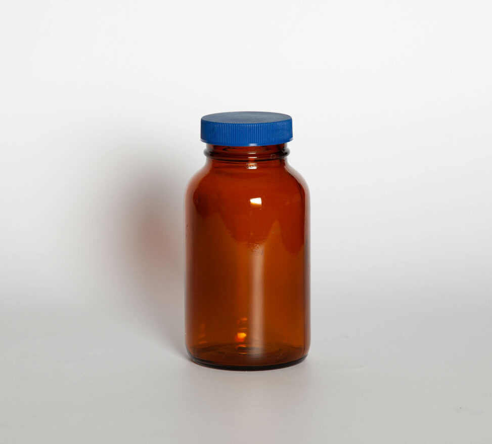 An amber glass bottle with its blue teflon-lined on it.