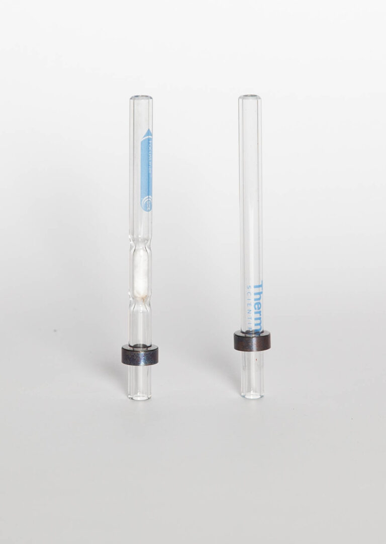 Two gas chromatography injector liners.