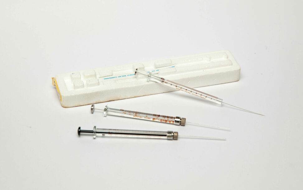 Three glass microsyringes with a foam microsyringe holder.