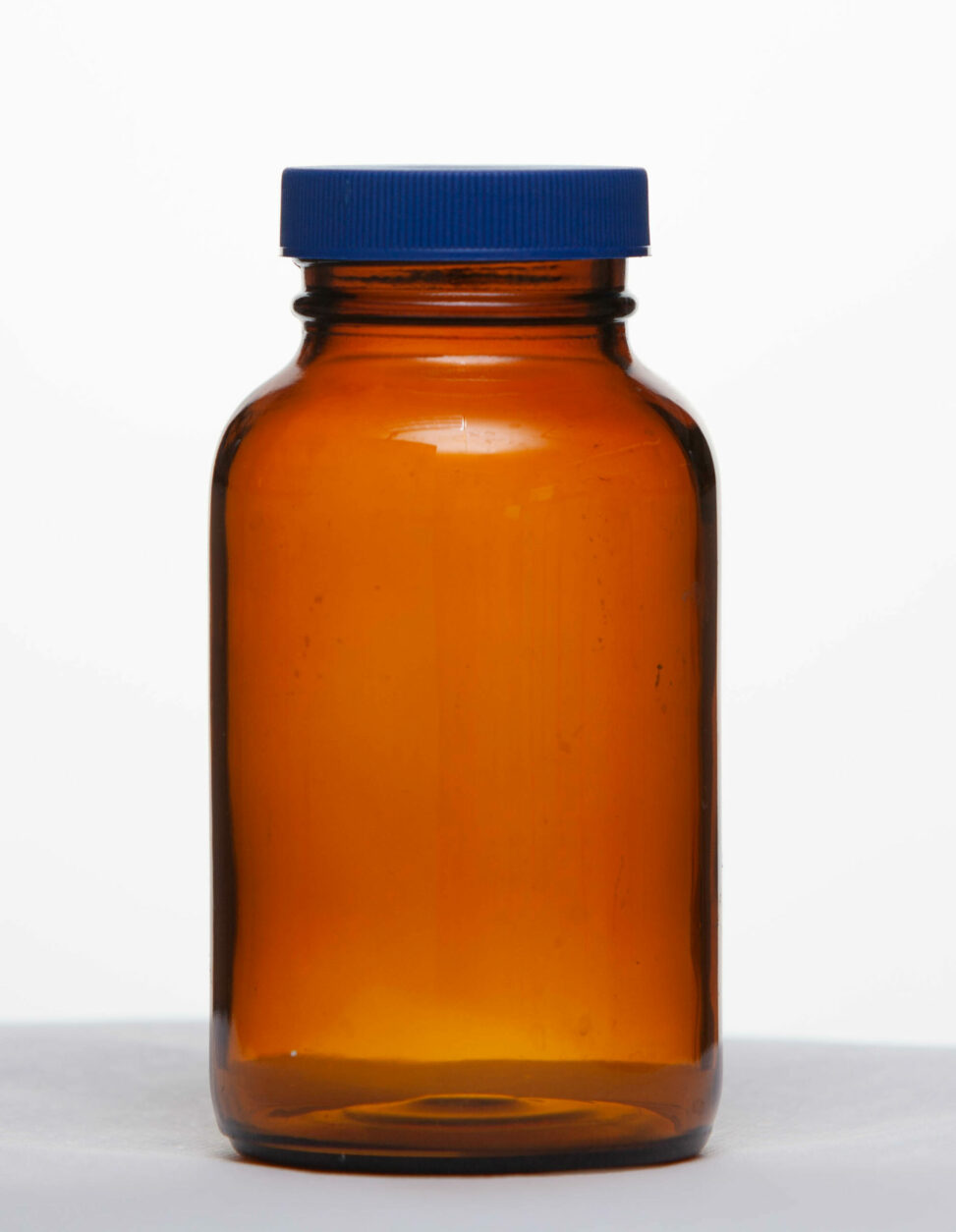 An amber bottle with a teflon-lined blue cap.