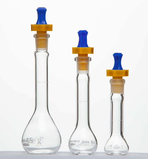 Three different sizes of volumetric flasks with blue and orange stoppers.