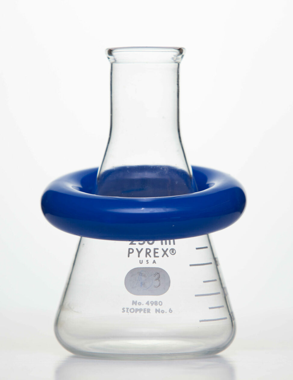 An Erlenmeyer flask with a blue ring weight around its centre.