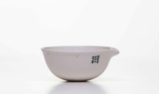 A ceramic evaporation dish with a lip for pouring on the side.