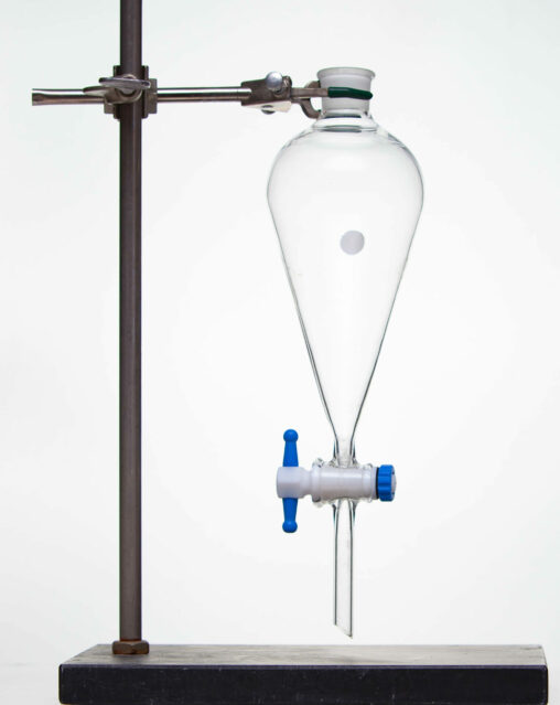 A glass separatory funnel held upright by a metal stand.