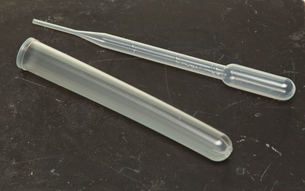 A plastic test tube beside a plastic Pasteur transfer pipette.