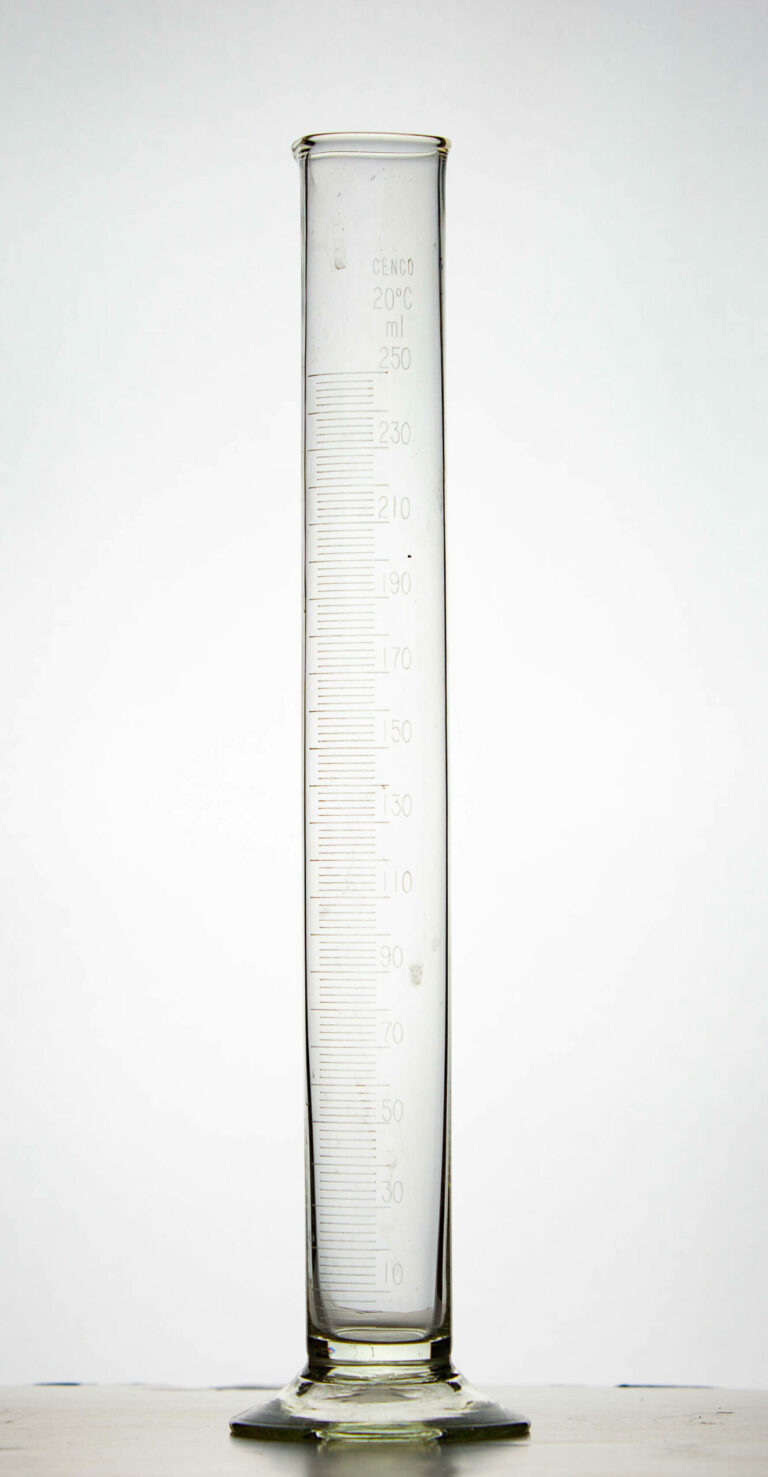 A glass graduated cylinder with a flat bottom.